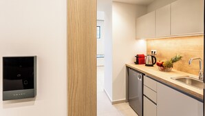 Eine moderne Küche mit integrierter Kaffeemaschine, einem Spülbecken und einer Holz Arbeitsplatte.