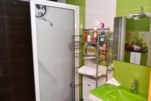 Chuveiro, toalhas de banho, sabonete, papel higiênico