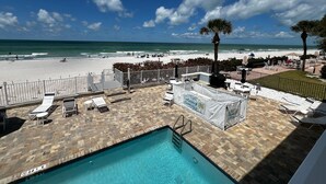 A pool area with a view of the beach and ocean.