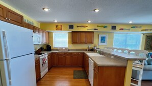A kitchen with wooden cabinets, a refrigerator, a stove, and a sink.