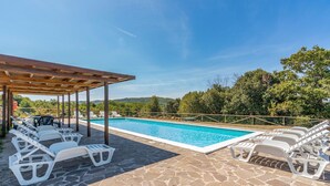 A swimming pool with lounge chairs and a pergola. - 2 bedroom amazing home in Sassetta (Sassetta)