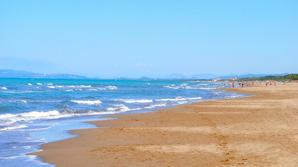 A beach with clear blue water, sandy shore, and distant mountains. - 2 bedroom amazing home in Sassetta (Sassetta)