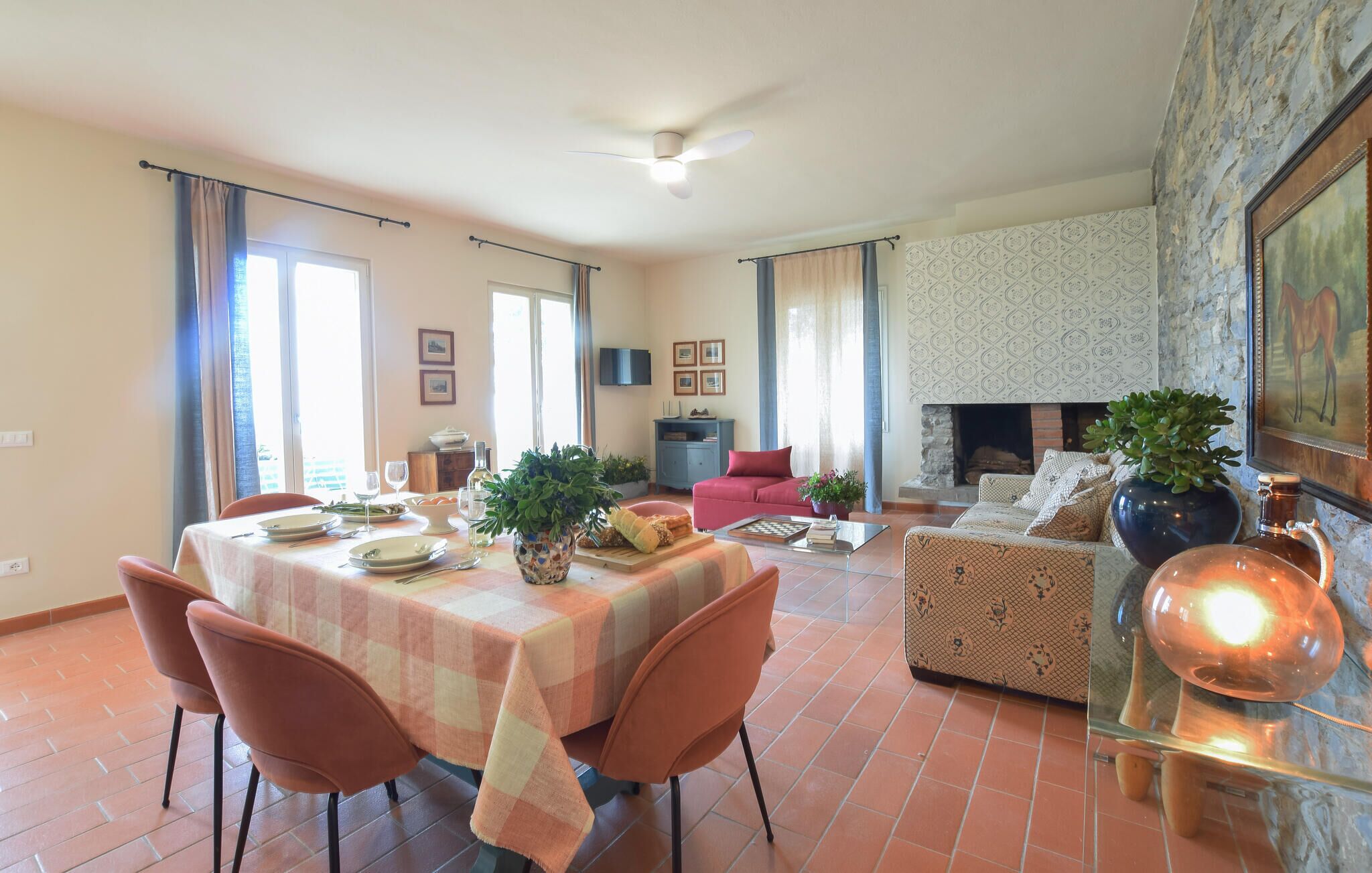 A dining area with a table set for four, a sofa, and a fireplace.