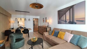 Un salon moderne comprenant un canapé, une table basse et un coin repas avec des chaises et une table.