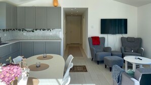 Een moderne woonruimte met keuken, eethoek en zithoek.