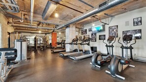 A gym with treadmills, elliptical machines, and weightlifting equipment.