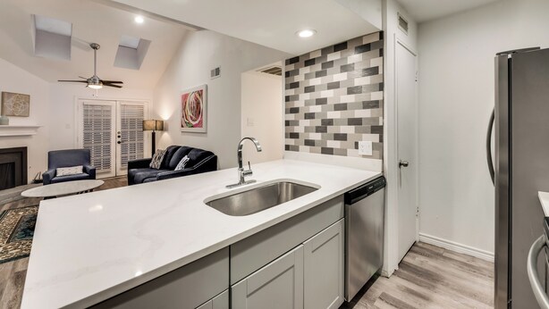 A modern kitchen with a large island, built-in dishwasher, and a refrigerator. - 2-bedroom condo in charming Dallas with WiFi, AC (Dallas)