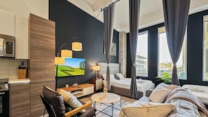 Une chambre d’hôtel moderne dotée d’un grand lit, d’un canapé, d’un coin repas et d’une cuisine.