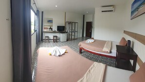 A hotel room with two beds, a desk with a computer, a wardrobe, and a window with curtains. - Athome Hotel Nanai 8 (Patong)