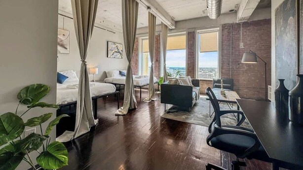 A hotel room with a large bed, a desk, and a view of the city. - Elegant 3BD | DT Dallas | Sleeps 9 | ValetParking (Dallas)