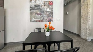A conference room with a black table, four chairs, and a poster on the wall.