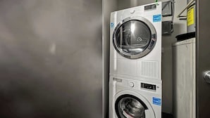 A stacked washer and dryer unit in a commercial setting.