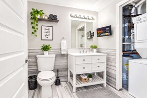A modern bathroom with a toilet, sink, vanity, and a mirror. - Luxury Studio | 2 Beds | Northern Liberties (Philadelphia)