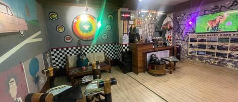 A cozy cafe with a checkered wall, a neon sign, and a TV displaying a zebra.