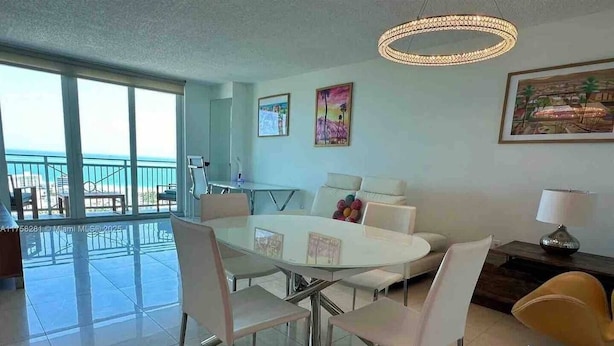 Ein modernes Wohnzimmer mit Essbereich, großen Fenstern und Meerblick.