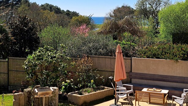 A patio with outdoor furniture, a grill, and a view of the sea. - Stone House by Beach in Pont-aven (Tregunc)