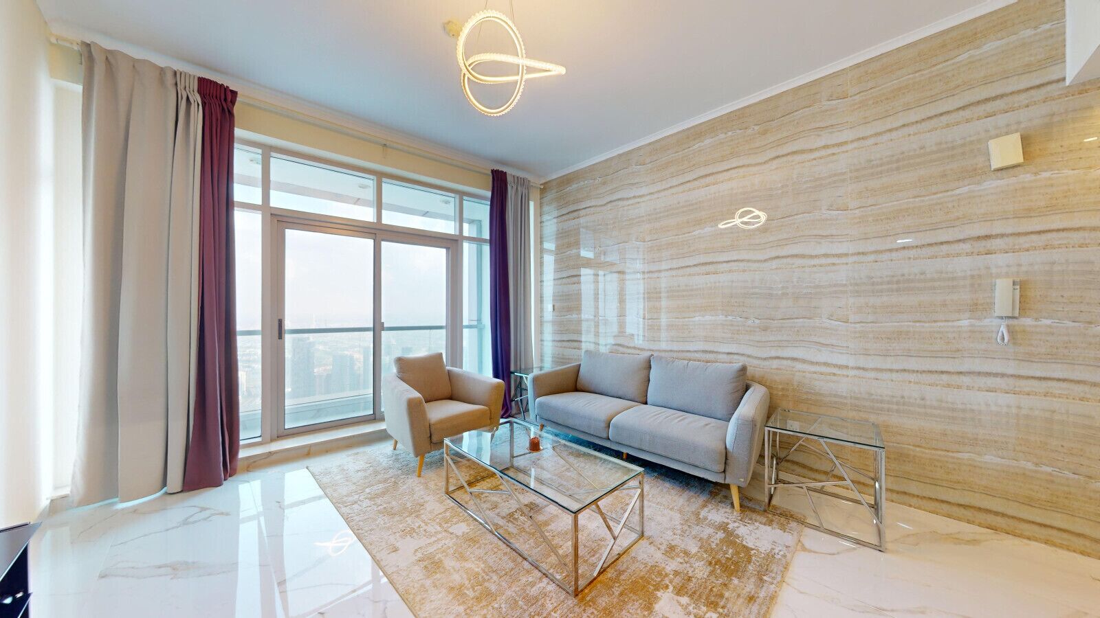 A modern living room with a sofa, armchairs, a glass coffee table, and a view of the city through large windows.