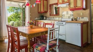 Una cocina con armarios de madera, una estufa y una mesa de comedor con sillas.