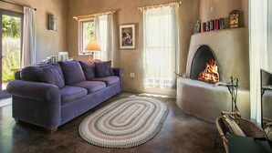 Una sala de estar acogedora con chimenea, un sofá y una alfombra.