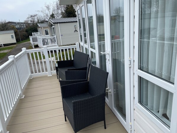 A balcony with wicker furniture and a white railing.