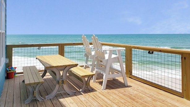 A wooden deck with a table and chairs, overlooking a beach with a clear view of the ocean. - Beach Blast: Gulf-Front 3bd/2ba on North Cape - Ocean Views From Every Room (Port St. Joe)