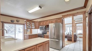 A kitchen with wooden cabinets, stainless steel appliances, and a large island.