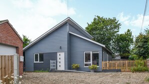 A single-story house with a gabled roof, a front door, and a small porch area. - Perfect for families and couples alike, a short walk to the lovely sandy beach. (Hemsby)