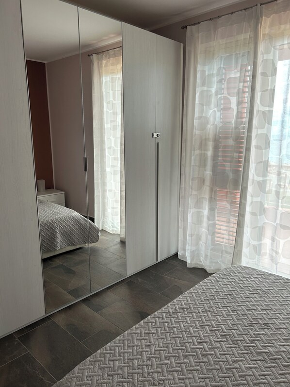 Un dormitorio con cama, armario y espejo.