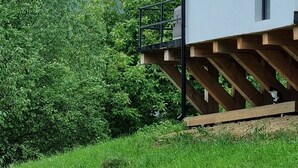 A modern building with a wooden deck and a view of a mountainous landscape.