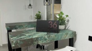A modern dining area with a rustic wooden table, two white chairs, and hanging pendant lights. - Far from nothing and close to everything.  (AN)