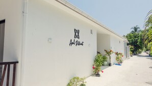 A white building with a sign reading "Aloha Retreat" and potted plants along the side. - Azul Retreat (Dhigurah)