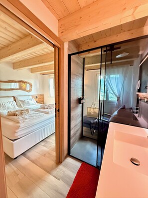 A bedroom with a bed, a sliding door leading to a bathroom, and a red rug.
