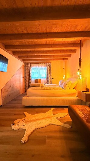Ein gemütliches Schlafzimmer mit Bett, Nachttisch, Lampe und einem großen Teppich mit Tierprint.