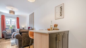 Une cuisine moderne avec un coin bar, une table à manger et un canapé dans le salon attenant.