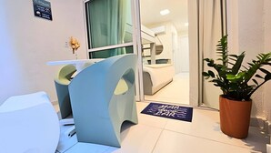 Un espace d’accueil moderne avec une porte en verre, un comptoir de réception et une plante en pot.