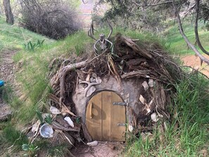 A rustic wooden door with a metal latch, surrounded by natural debris and vegetation. - Very Private, Close to all Glenwood attractions, Pets welcome. 420 friendly! (Glenwood Springs)