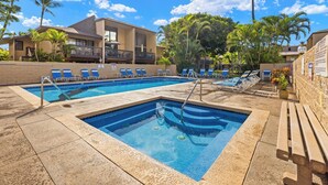 A pool area with lounge chairs and a building with a balcony. - Charming Tropical Kihei Gardens 2-Bed Suite (Kihei)