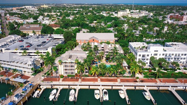 A marina with several boats docked, a building with a red roof, and a view of the surrounding cityscape. - Hyatt Sunset Harbor. Available Oct 19 to 26.   Studio. 3 night minimum rental.   (Key West)