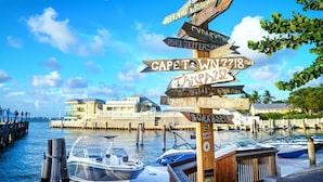 A wooden signpost with multiple directional signs pointing to various destinations and distances. - Hyatt Sunset Harbor. Available Oct 19 to 26.   Studio. 3 night minimum rental.   (Key West)