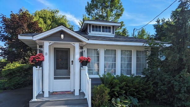 A house with a front porch, a small attached garage, and a covered entryway.