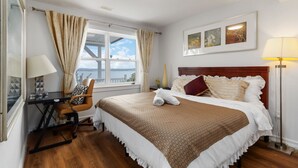 A hotel room with a bed, a desk, a chair, a lamp, and a window with curtains. - Luxury retreat with Amazing Views, Great Location with free parking! (Halifax)