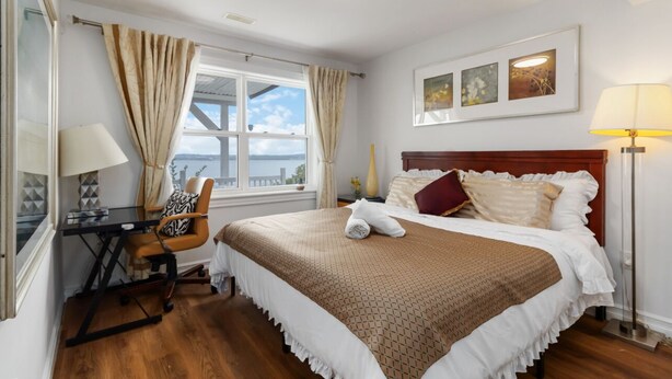 A hotel room with a bed, a desk, a chair, a lamp, and a window with curtains. - Luxury retreat with Amazing Views, Great Location with free parking! (Halifax)
