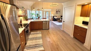 Een moderne keuken met een centraal eiland, houten kastjes en een roestvrijstalen koelkast.