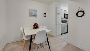 A modern kitchen with white cabinets and a microwave.