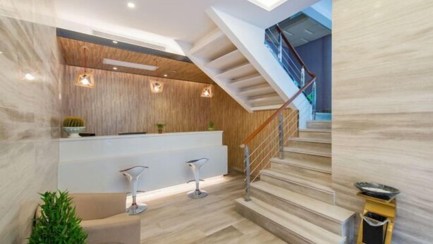 A modern interior with a staircase, a reception desk, and a bar area. - Shanghai Nalan Hotel (Shanghai)