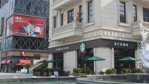 Un café Starbucks avec une terrasse et une fontaine.