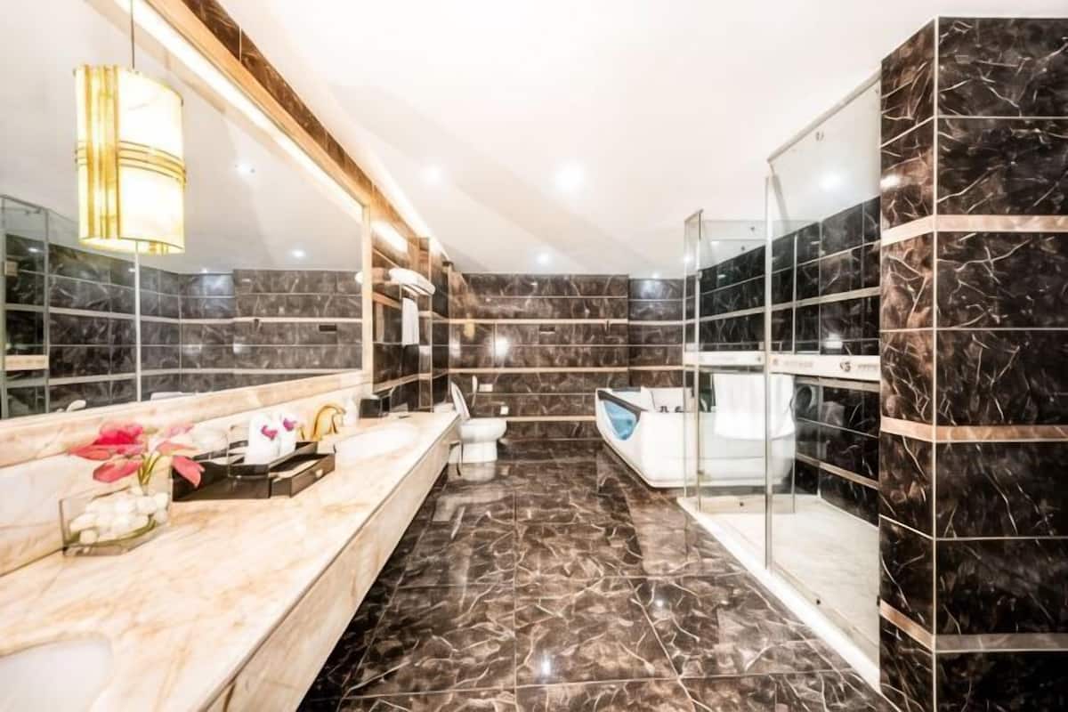 A modern bathroom with a marble vanity, a glass shower enclosure, and a large mirror.