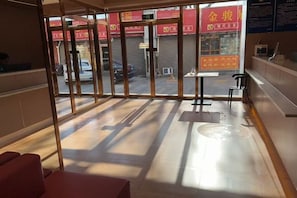 A hotel lobby with a glass partition, a reception desk, and a view of the street outside. - 7Days Inn chain hotel (Beijing West Railway Station Maliandao Wan Zi Subway Station) (Beijing)