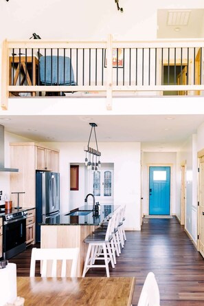 A spacious kitchen with a central island, wooden cabinets, and a modern stainless steel refrigerator. - Alum Ridge Retreat by Buffalo Mountain Getaway (Riner)
