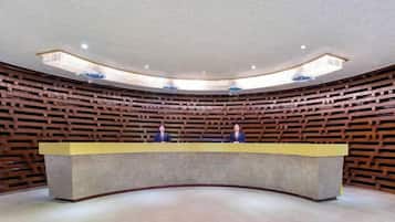 A modern reception area with a curved counter and wooden paneling on the walls.